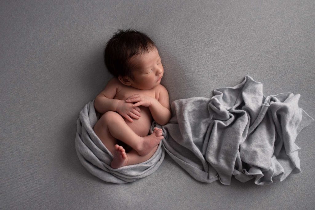 Bébé endormi sur fond gris - Photographe naissance Paris